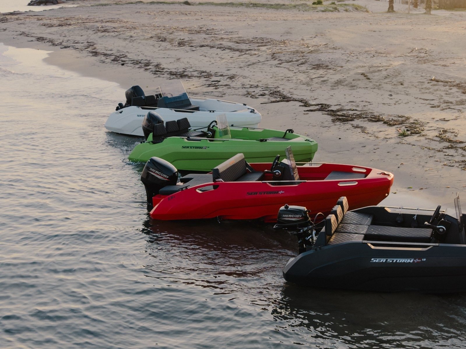 SeaStorm boats in white, lime, red and dark grey at the water's edge